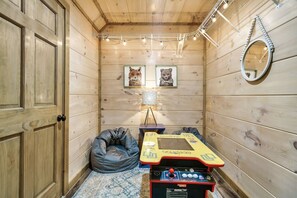 Relax in this inviting room with a bean bag chair and arcade game console.