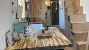 Een moderne keuken met een houten kookeiland, inbouwplanken en een entresol.