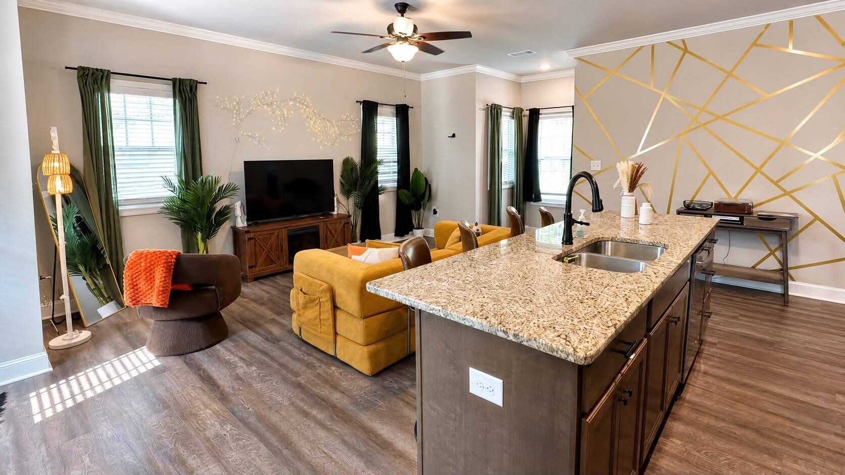 A modern living room with a sofa, a TV, and a dining area with a kitchen island.