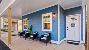 Ein blaues Haus mit Veranda, Nummer 261, und einem Willkommensschild.