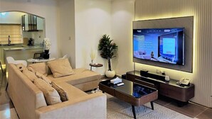 Ein modernes Wohnzimmer mit einem Ecksofa, einem Couchtisch und einem flachbildfernseher an der Wand.