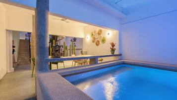 Een buitenzwembad, parasols bij het zwembad en ligstoelen