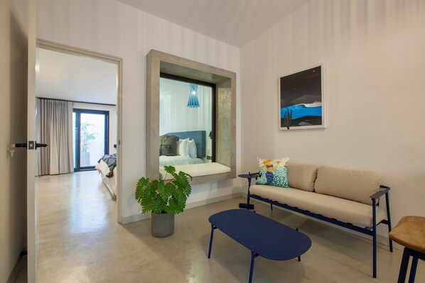 Una sala de estar moderna con un sofá, una mesa de centro y una planta en maceta.