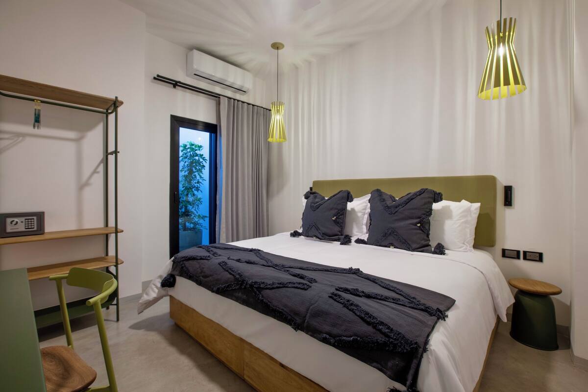 Una habitación de hotel moderna con una cama grande, un escritorio y una silla.