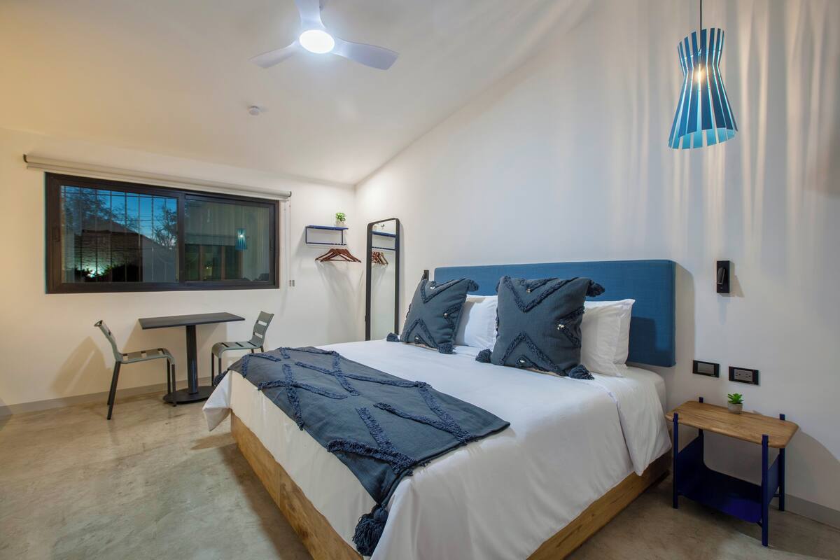 Un dormitorio moderno con una cama grande, un escritorio y una silla.