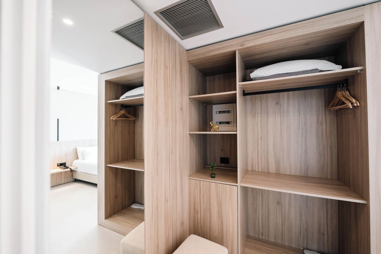Un dormitorio moderno con armario empotrado, mesita de noche y lámpara colgante.