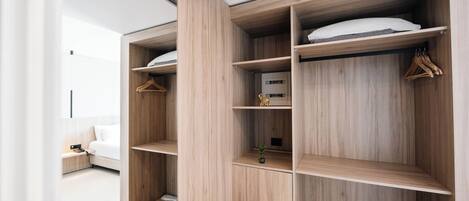 Un dormitorio moderno con armario empotrado, mesita de noche y lámpara colgante.
