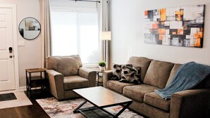 A living room with a sofa, a coffee table, and a lamp.
