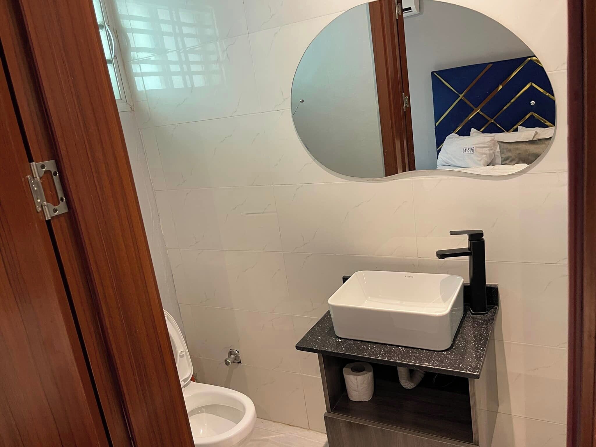 Ein Badezimmer mit Toilette, Waschbecken mit Spiegel darüber und einer Duschkabine.