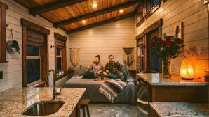 Una cocina acogedora con vigas de madera, encimera de granito y una zona de estar con una mesa.