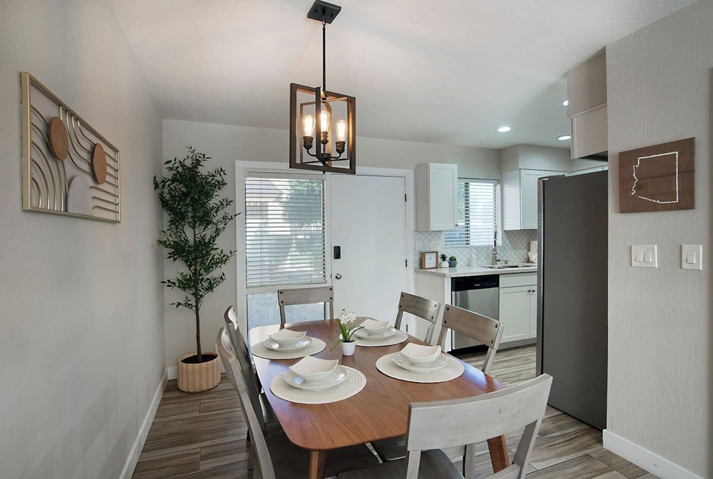 A modern kitchen with white cabinets, a built-in oven, and a refrigerator.