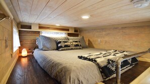 Une chambre confortable avec un lit, des oreillers, un radiateur et une fenêtre.