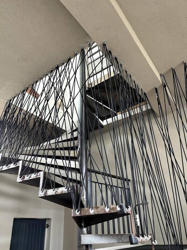 A modern, industrial-style staircase with exposed metal beams and cables.