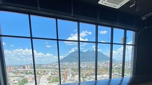 Ein Restaurant mit großem Fenster und Blick auf Stadtpanorama und Berglandschaft.