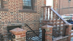Un bâtiment en briques avec une porte en métal et un escalier menant au deuxième étage.