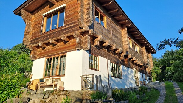 A log cabin with a balcony, stone foundation, and a stone wall. - Quiet vacation apartment in a wooden house (on the edge of the forest) (Modautal)