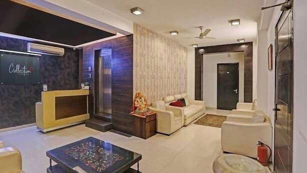 A modern lobby with a reception desk, seating area, and a decorative statue. - Global luxary stay  (Gurugram)