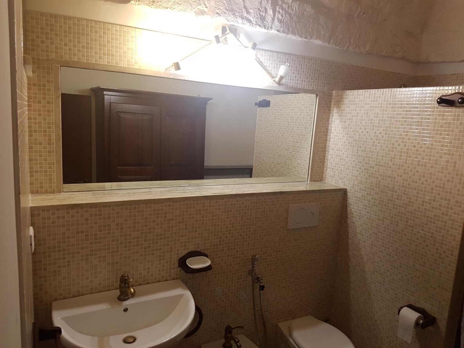 Ein Badezimmer mit Waschbecken, Toilette und Spiegel.