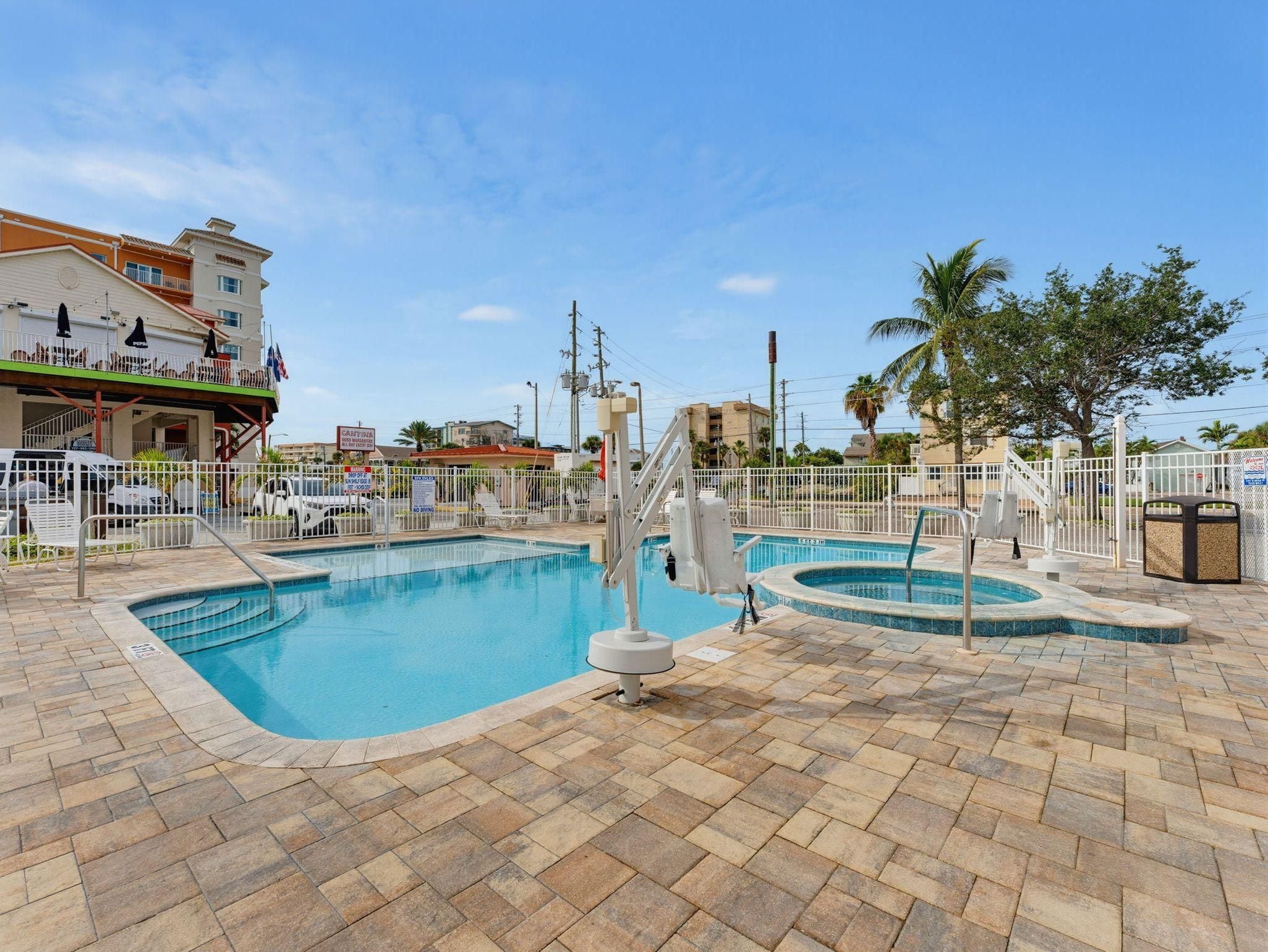 A swimming pool with a diving board and a separate hot tub area.
