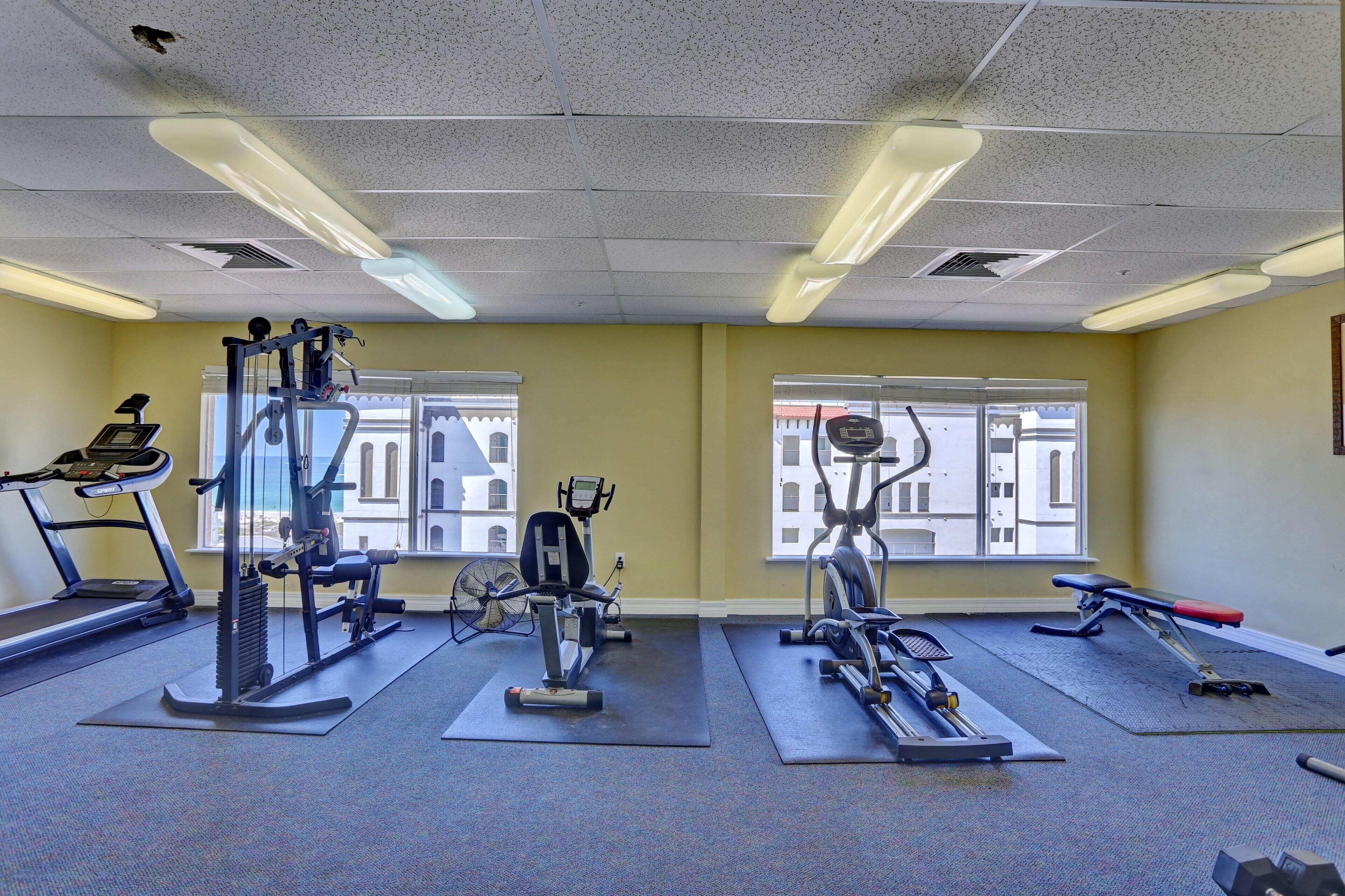 A gym with treadmills, elliptical machines, and weight benches.