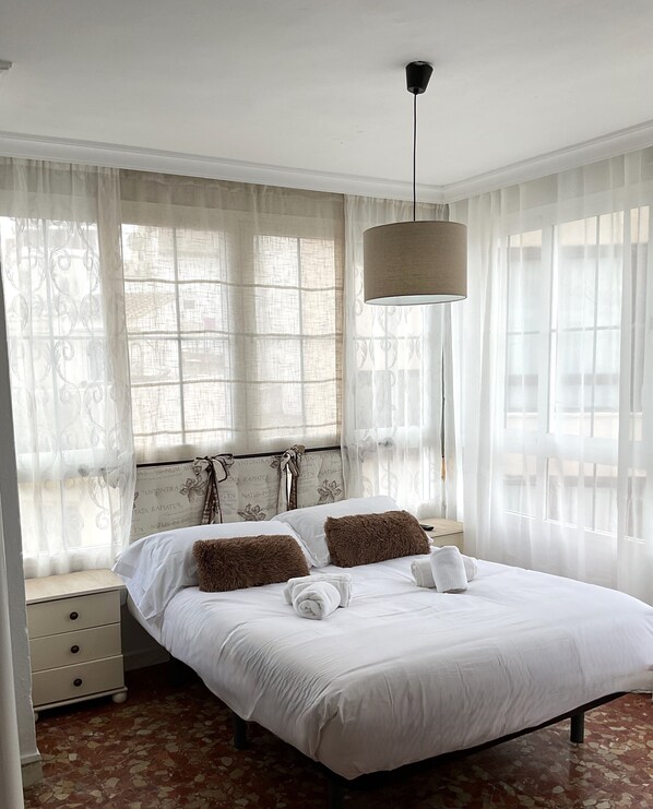 Cozy retreat with a large bed, wooden headboard, and a nightstand with a drawer.