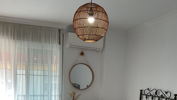 Une chambre d’hôtel avec deux lits, un bureau, une chaise, un luminaire suspendu et un miroir.