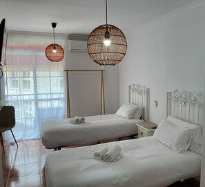 Two single beds with crisp linens and nightstands offer a comfortable retreat.