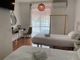 Une chambre d’hôtel avec deux lits, un bureau, une chaise et une grande fenêtre donnant sur un beau paysage.