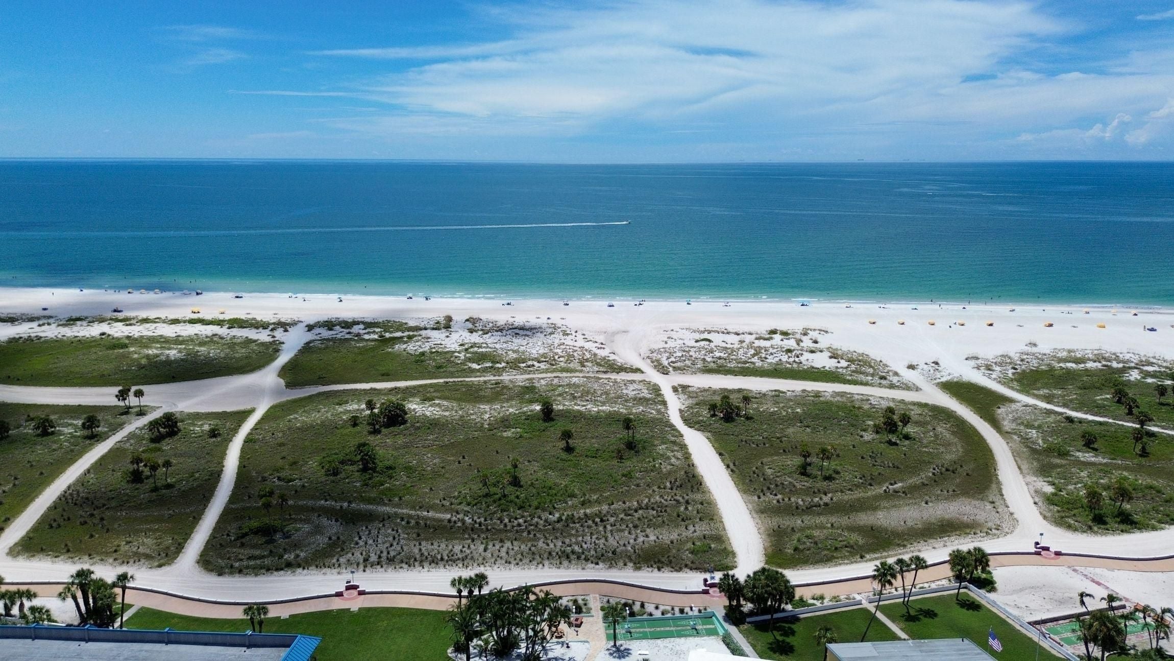 Une zone de plage côtière avec de nombreux sentiers et quelques bâtiments.