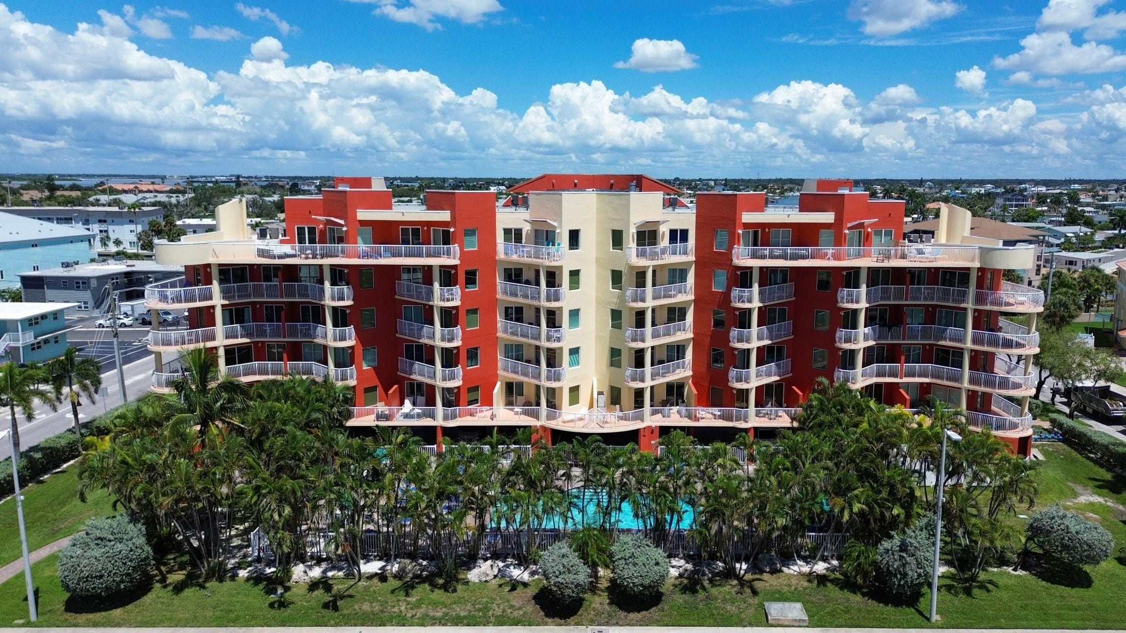 Un hôtel à plusieurs étages doté de balcons, d’une piscine et offrant une vue sur les environs.