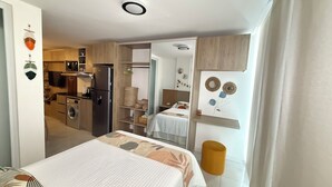 A modern hotel room with a bed, a small bathroom, and a kitchenette. - A must-see studio apartment in Sirari-Equipetrol (Santa Cruz de la Sierra)