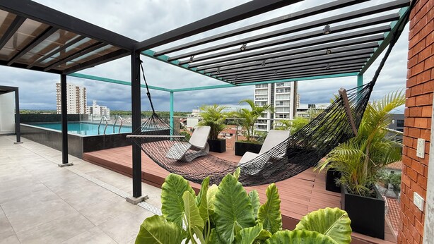 A rooftop terrace with a pool, outdoor seating, and a view of surrounding buildings. - A must-see studio apartment in Sirari-Equipetrol (Santa Cruz de la Sierra)