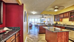 A modern kitchen with granite countertops, wooden cabinets, and a central island.