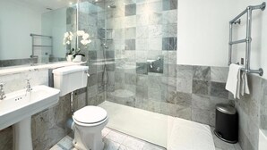 A modern bathroom with a glass-enclosed shower, a toilet, a sink, and a towel rack. - Museum ST Central Soho Apartment (Greater London)