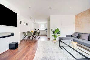 Una sala moderna con sofá, mesa de centro y comedor con sillas y mesa.