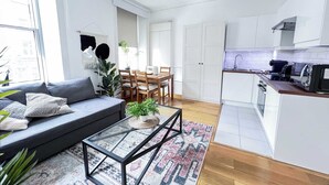 Un appartement moderne comprenant un coin repas, une cuisine et un salon.