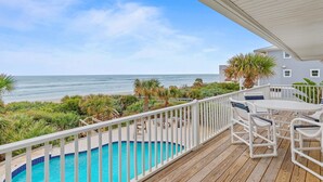 A wooden deck with a pool, outdoor furniture, and a view of the beach and ocean. - Blue Yonder Beach House (New Smyrna Beach)