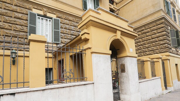 A yellow building with a stone facade, a metal gate, and a number '40' sign. - Stylish&Renovated Apt in Trastevere ac/wi-fi (Roma)