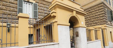 A yellow building with a stone facade, a metal gate, and a number '40' sign.