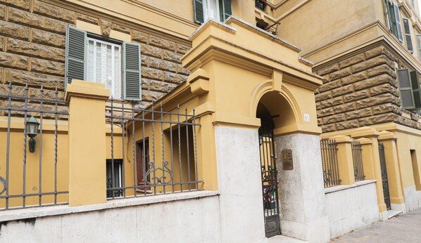 A yellow building with a stone facade, a metal gate, and a number '40' sign.