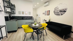 A modern living space with a kitchen, dining area, and a black sofa. - Stylish&Renovated Apt in Trastevere ac/wi-fi (Roma)
