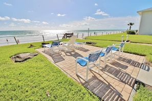 A patio with outdoor seating and a view of the ocean.