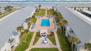 Un resort con piscina, vista al mar y varias habitaciones de huéspedes.