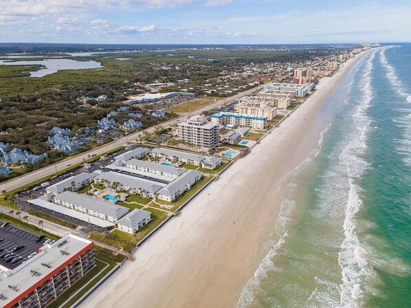 A coastal hotel with multiple buildings, a beach, and a marina. - Colony Beach Club 204 (New Smyrna Beach)