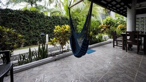A hammock hanging over a tiled patio with a garden view. - Villa Junior # 1 w/ Pool & Kitchen – Minutes from Manuel Antonio Beach (Quepos)
