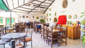 A restaurant with a high ceiling, wooden chairs, tables, and a variety of wall decorations. - Villa Junior # 1 w/ Pool & Kitchen – Minutes from Manuel Antonio Beach (Quepos)