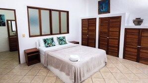 A bedroom with a bed, wooden wardrobe, and a mirror. - Villa Junior # 1 w/ Pool & Kitchen – Minutes from Manuel Antonio Beach (Quepos)