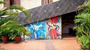 A building entrance with a colorful mural, potted plants, and a tiled floor. - Ai-Royal Hotel & Suites (Ikorodu)