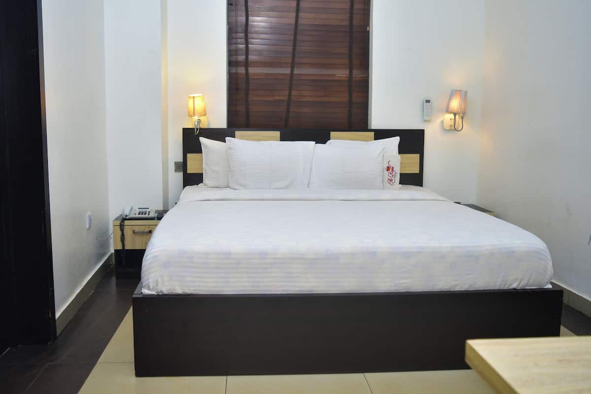 Una cama bien hecha con sábanas blancas en una habitación de hotel.