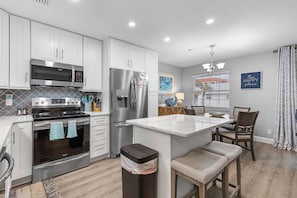 Enjoy cooking in this well-equipped kitchen with stainless steel appliances, a marble island, and a dining area.